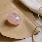 Rose quartz on kraft paper with twine, soft light