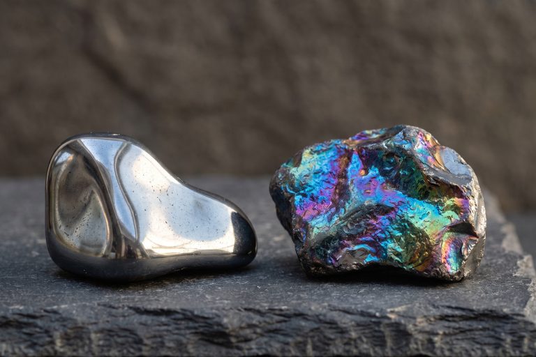 Shiny metallic and rainbow hematite on a dark surface