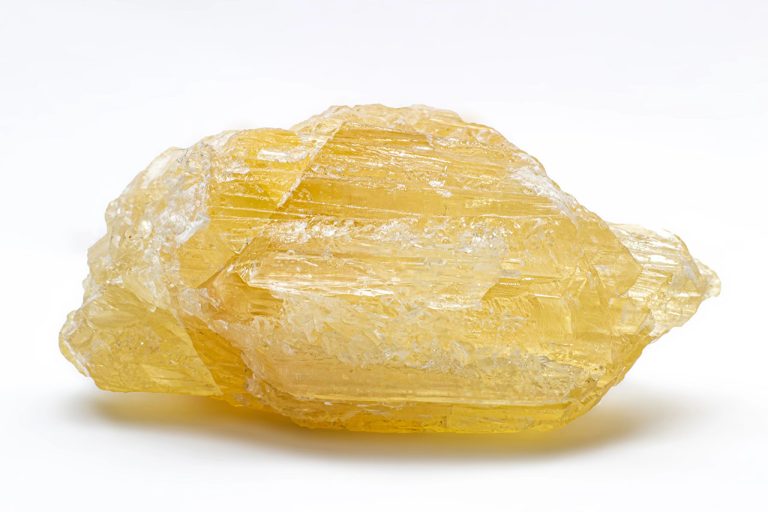 Raw pale yellow calcite on white background