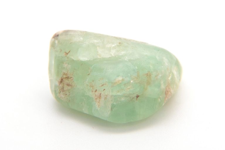Green beryl crystal with hexagonal structure on white background