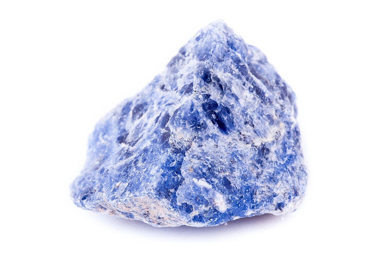 Raw sodalite specimen with rough blue surface, white calcite veining, and natural angular crystalline texture.