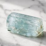 Aquamarine crystal from Crystalance on marble surface.