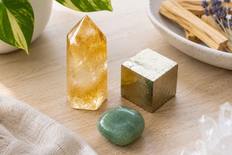 Healing crystals including citrine, pyrite, and aventurine on a wooden surface.