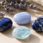 Beautiful collection of blue and white healing crystals on wooden surface.